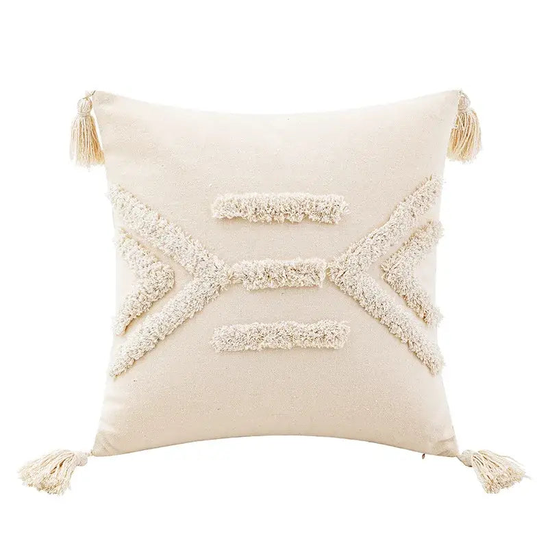 Cream-colored tufted cushion cover with off-white woven geometric patterns and matching tassels for living room use