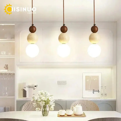 Three modern beige stone pendant lights with wooden accent tops and dark cord pendant for dining room lighting