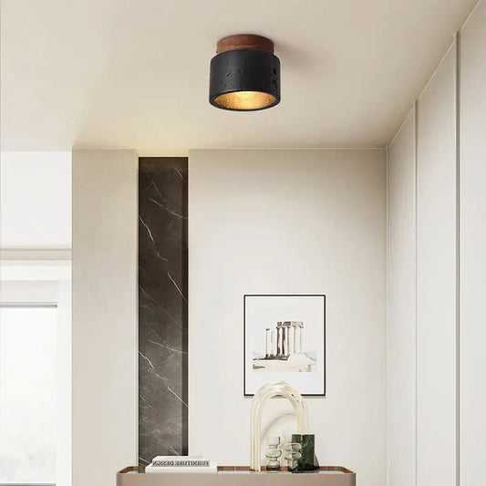 Wabi-sabi black natural stone pendant light with wooden top and textured finish emitting warm glow for dining room