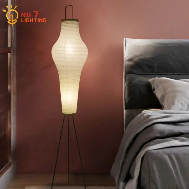 A tall cream paper tripod floor lamp with a black metal base ideal for living room art decor