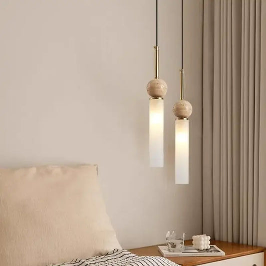 Two minimalist pendant lights with cream stone spherical tops and brass fixtures for cord pendant installation