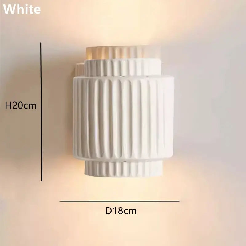 Cream white resin wall lamp with vertical ridged texture and tiered cylindrical design for bedroom use