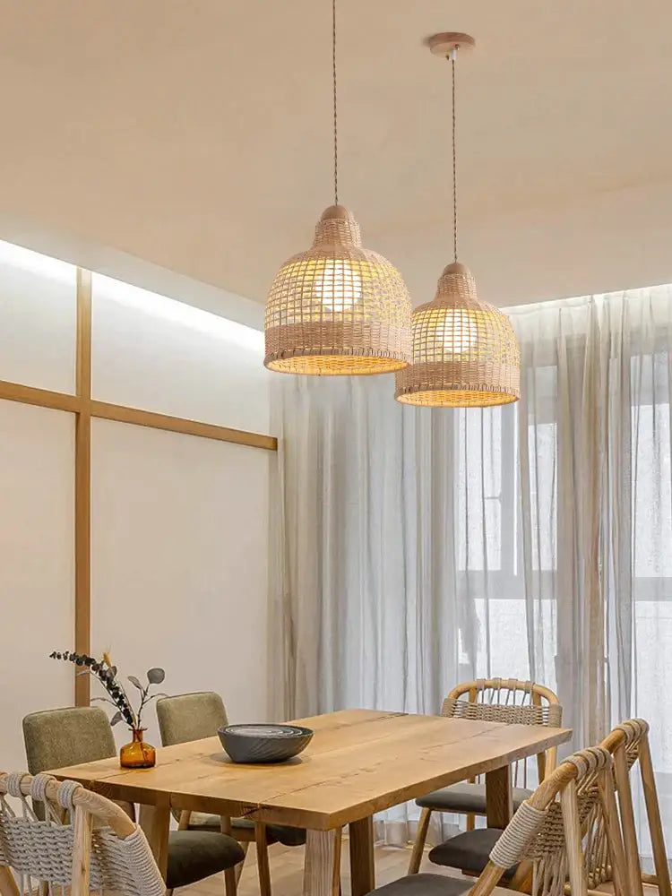 Two woven rattan decorbites bamboo pendant lamps in warm beige hang over a dining room island