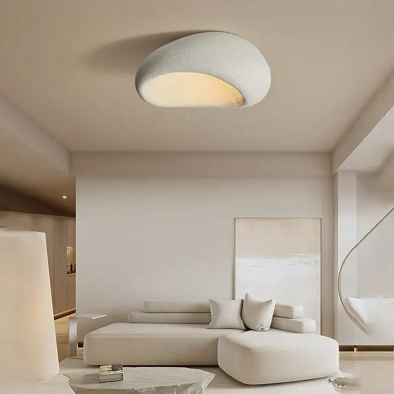 A modern wabi sabi matte cream ceiling chandelier with a smooth oval shape and soft diffused glow for bedrooms