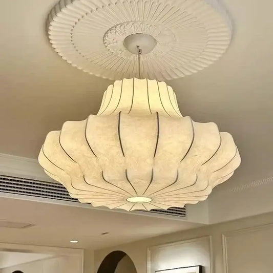Cream-colored wabi sabi pleated pendant light with subtle black outline detail and led bulb for bedroom use