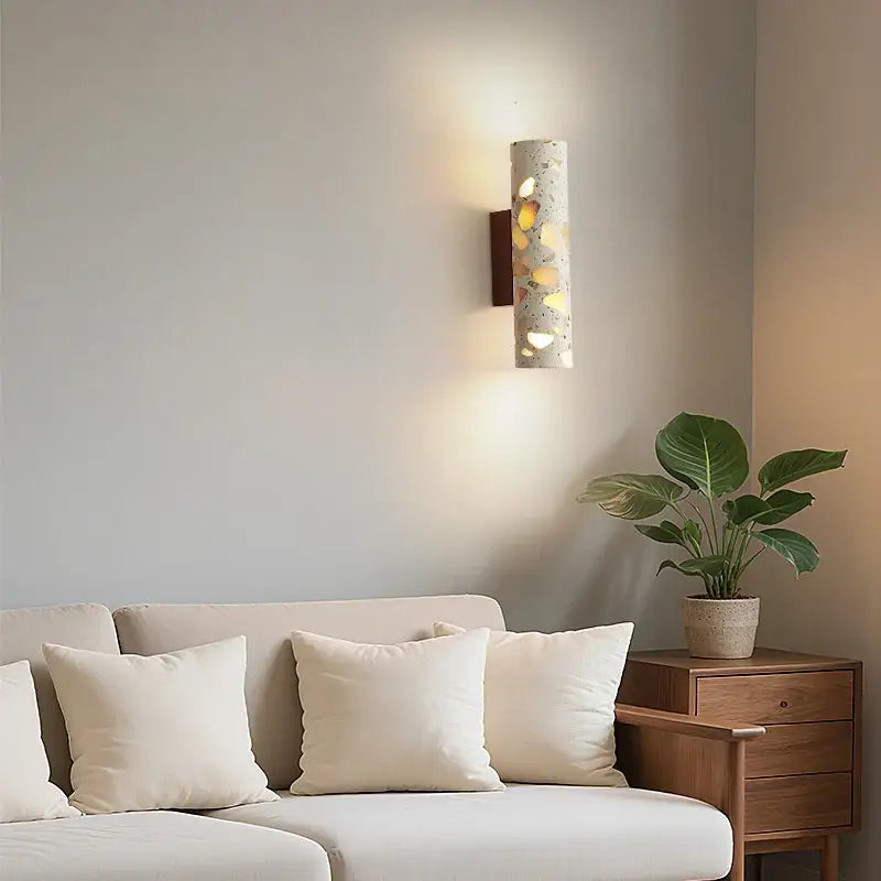 A cylindrical concrete wabi sabi terrazzo and wood led wall light with golden accents and dark wood backplate for bedroom decorbites led wall lights