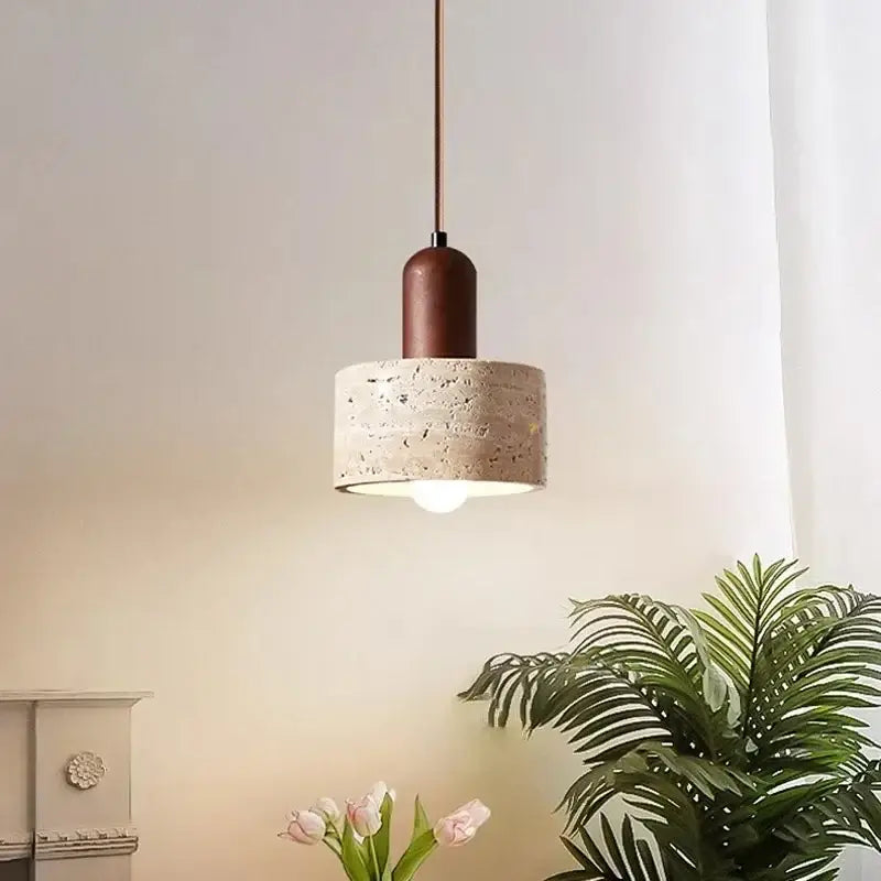 A modern wabi sabi yellow stone pendant light with a cylindrical concrete shade and copper-toned metal stem