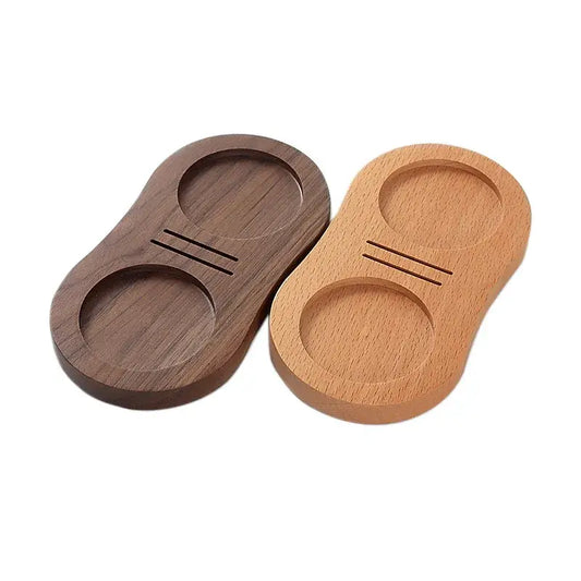 Two wooden tamping stations in dark walnut and light oak with circular indentations and grooves for espresso tampers