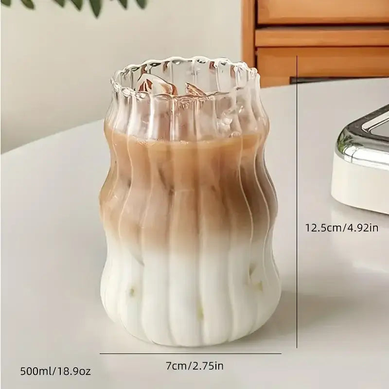 A clear wavy ribbed glass cup 500ml ins glass cup with fluted rim containing gradient iced coffee