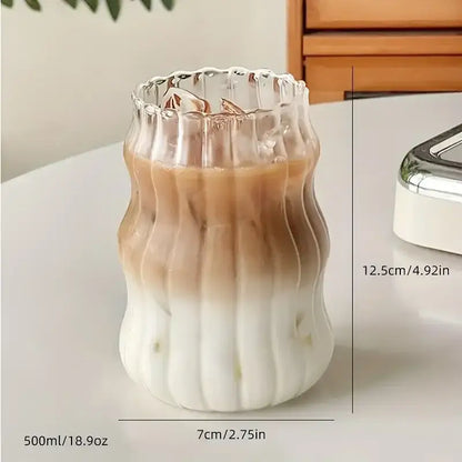 A clear wavy ribbed glass cup 500ml ins glass cup with fluted rim containing gradient iced coffee