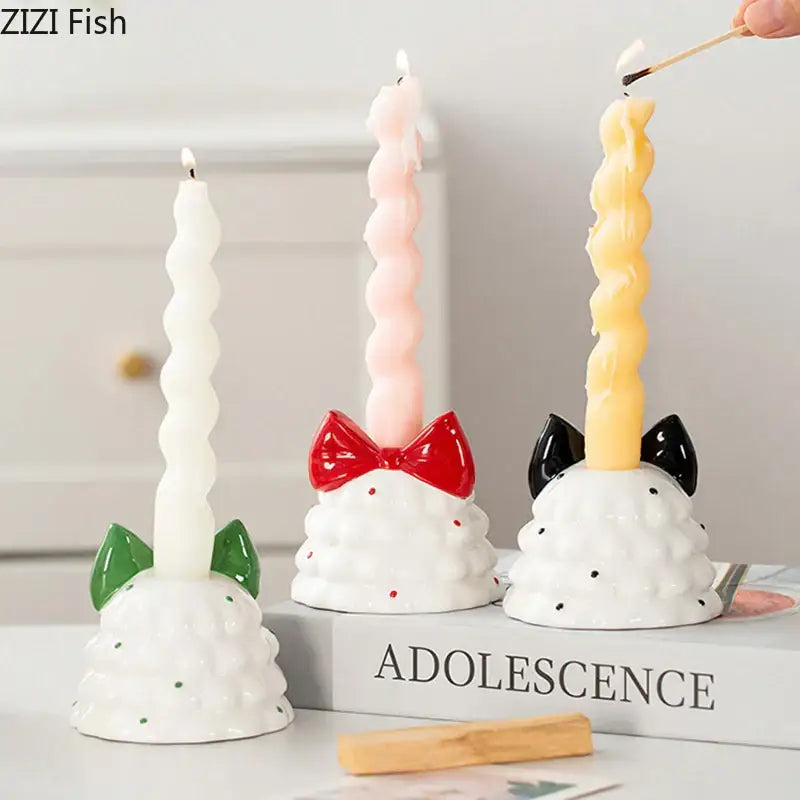 Three whimsical ceramic bowknot tree candle holders with textured white bases and colorful twisted candles for decorbites decor