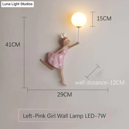 Whimsical pink girl wall lamp with white polka dots featuring a dancing figure holding an illuminated globe bulb