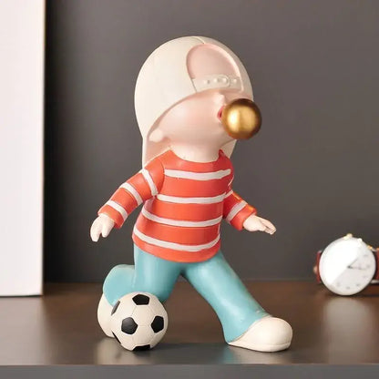 Whimsical resin boys sports statue of child in orange striped shirt blowing golden bubble gum ball for decorbites boys sports decor