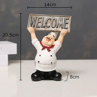 A cheerful white bearded chef resin figure with black boots holding a weathered silver welcome sign for kitchen decor
