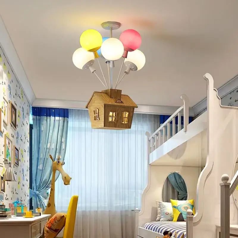 Whimsical wooden house balloon ceiling chandelier with glowing windows and colorful yellow pink and white balloon ceiling lamps for nursery