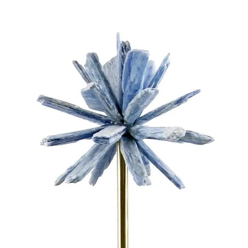 Delicate blue crystal cluster pin with starburst design on gold stem alongside white agate flower home decor figurine