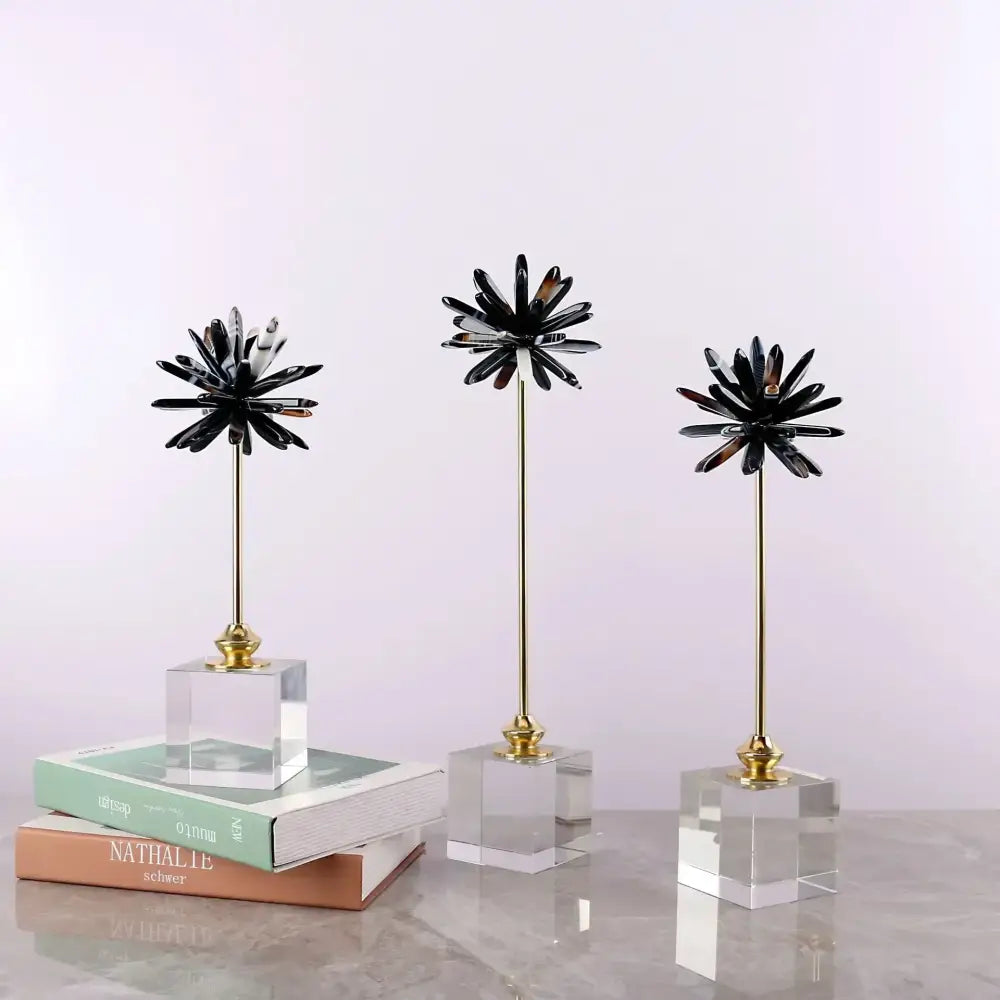 Three black starburst home decor figurines with gold stems on clear acrylic bases for living room decor