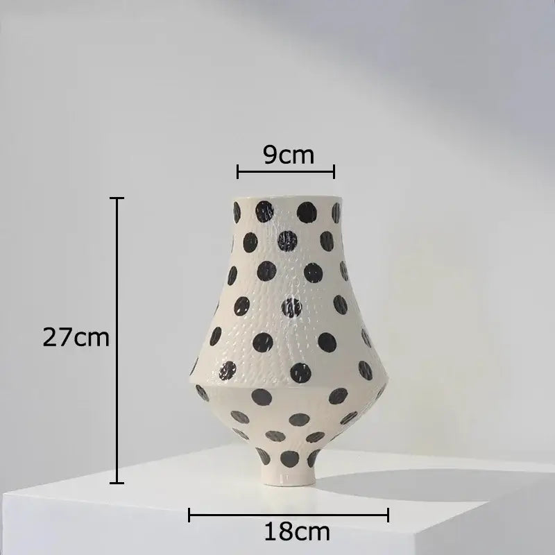 A sleek 27cm white ceramic vase with black polka dot texture and asymmetrical modern silhouette for living room decor