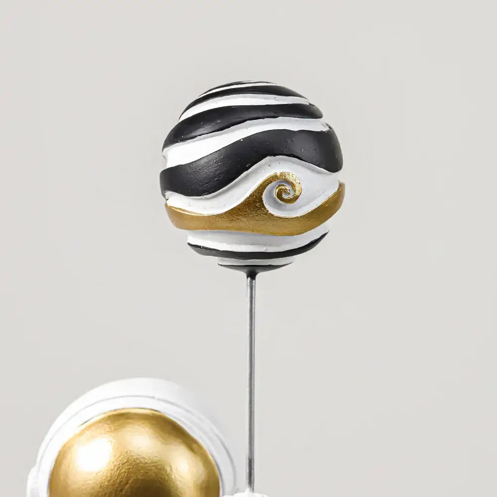 Black and white striped spherical ornament with gold spiral on metallic stem in decorbites astronauts figurines gold set
