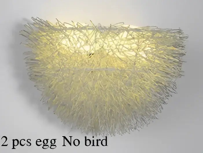 White and gold ceramic birds nest wall lamp with woven wireframe design emitting warm yellow glow for children room