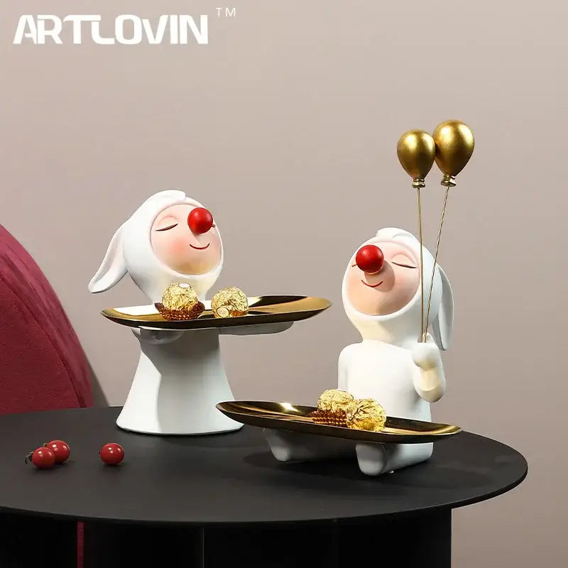 White and gold ceramic clown bust sculpture with red noses holding candy trays with gold foil chocolates for kids room
