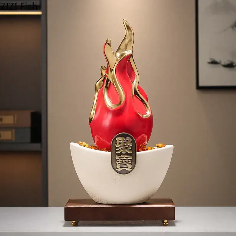 A glossy red and gold flame-shaped feng shui ornament with chinese characters on a white ceramic base and wood stand