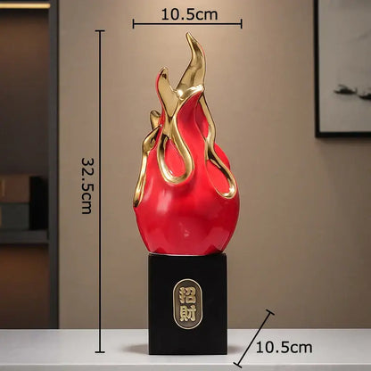 A glossy red and gold flame-shaped feng shui ornament with black base and chinese characters for living room decor