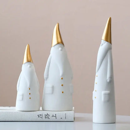 Three white ceramic santa claus figurines with gold-tipped hats and button details for christmas decor