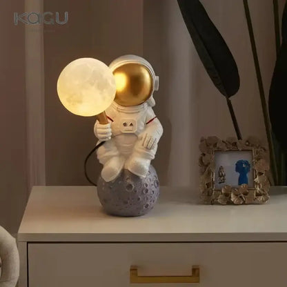 White and gold decorbites astronaut moon wall lamp with glowing lamp on gray moon planet table base for bedroom light