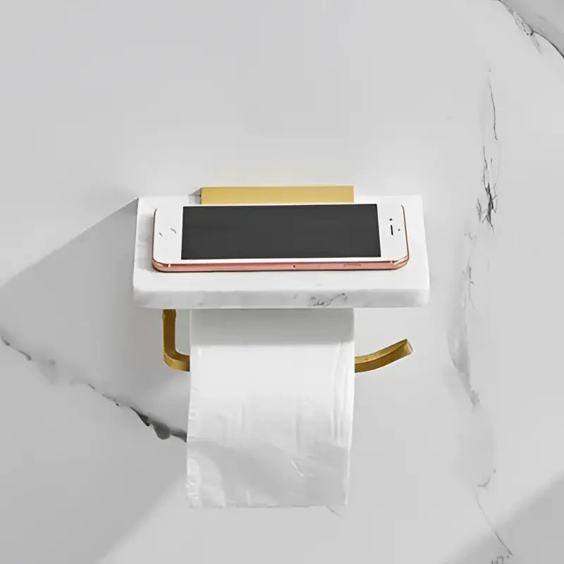 White and gold marble toilet paper holder with gold marble metal accents and a sleek rectangular iphone platform decorbites gold marble