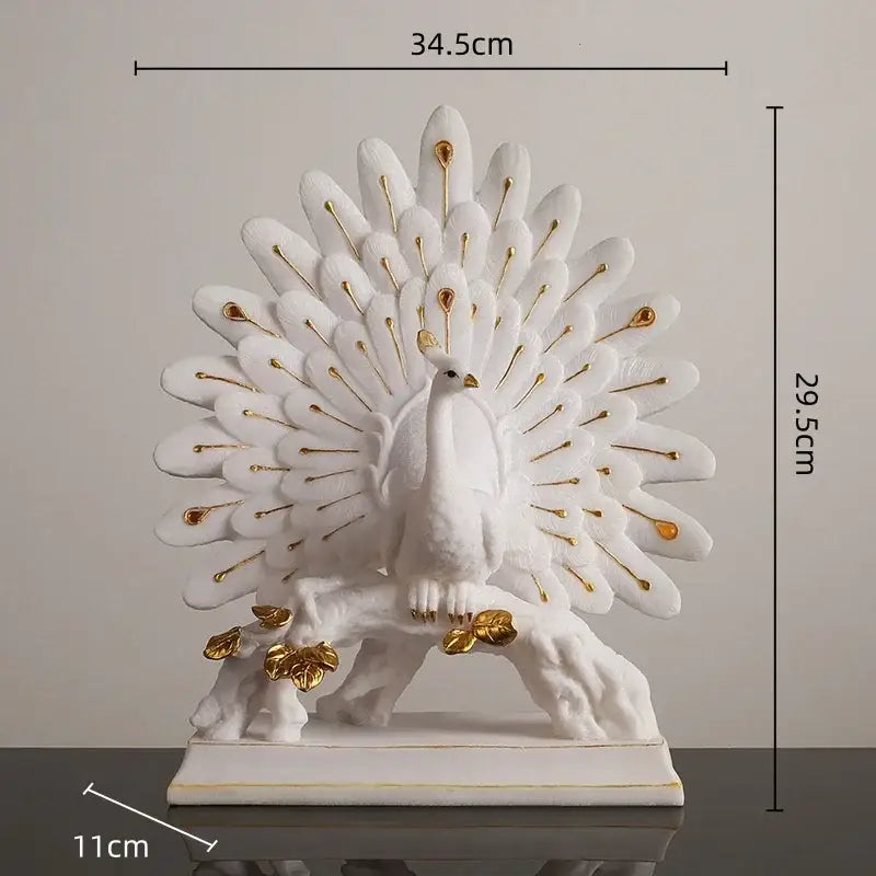 White and gold peacock sculpture with gold accents on feathers and feet standing on sculpted branch base for home decor