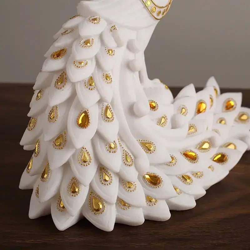 White and gold peacock sculpture with intricate feathers and golden teardrop embellishments for home decor by decorbites golden phoenix