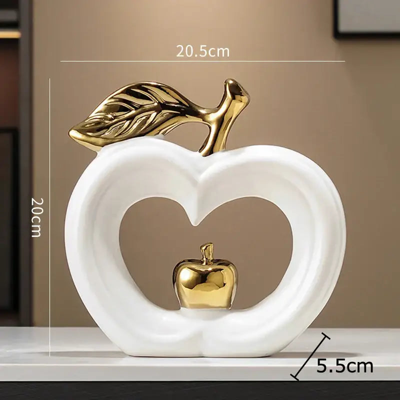 White and gold pear ceramic desk ornament with gold leaf and heart cutout holding miniature golden apple decorbites gold pear