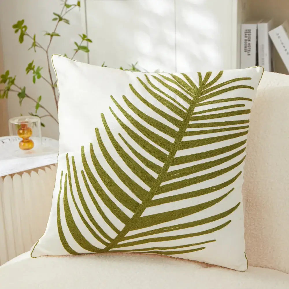 White pillow cover with olive green embroidered leaf design perfect for living room décor and comfort