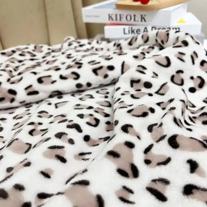 A plush white and orange leopard print warm fleece throw blanket with soft fuzzy texture for cozy decorbites leopard print decor