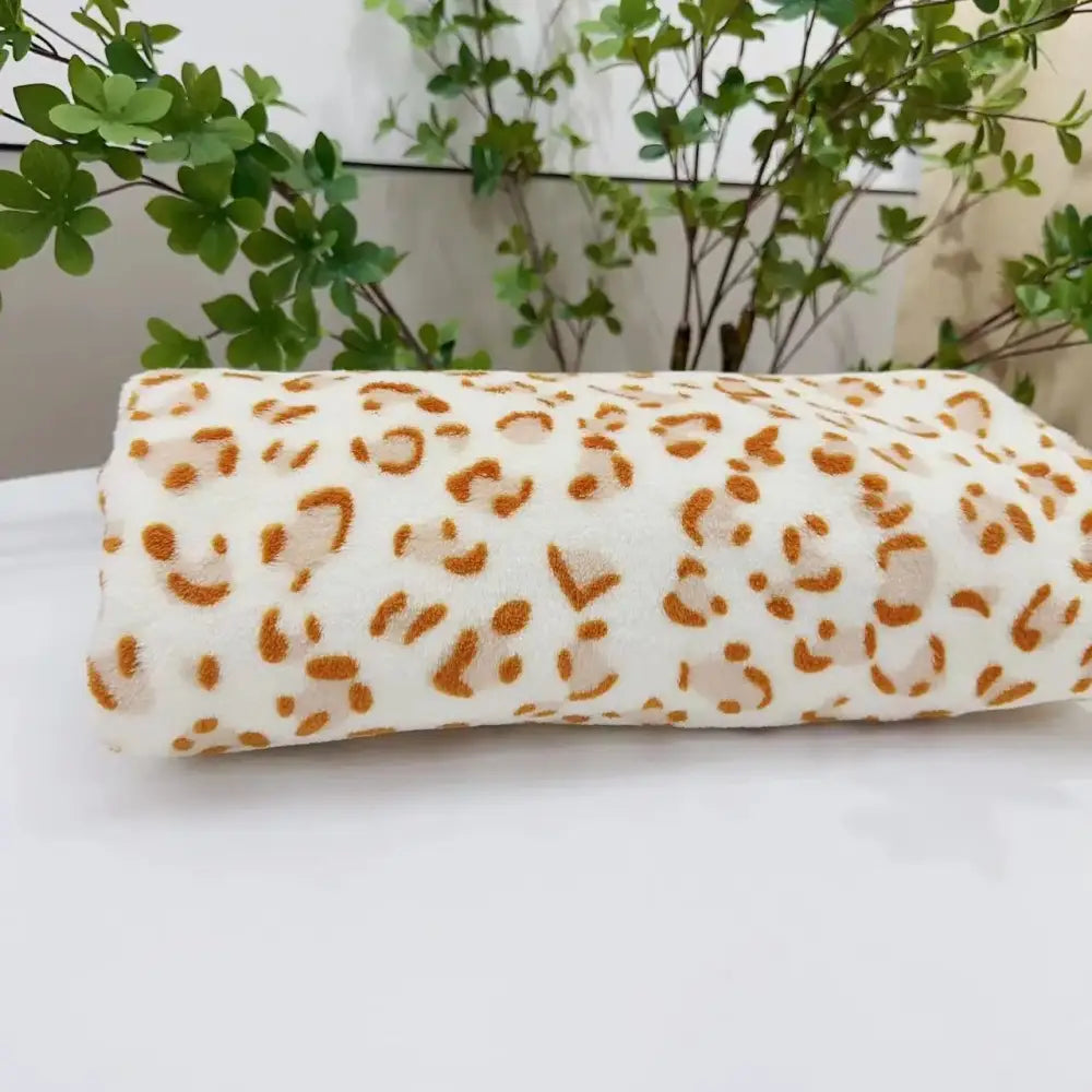 A soft white fleece throw with subtle orange leopard print pattern perfect for warm decorbites leopard print bedding