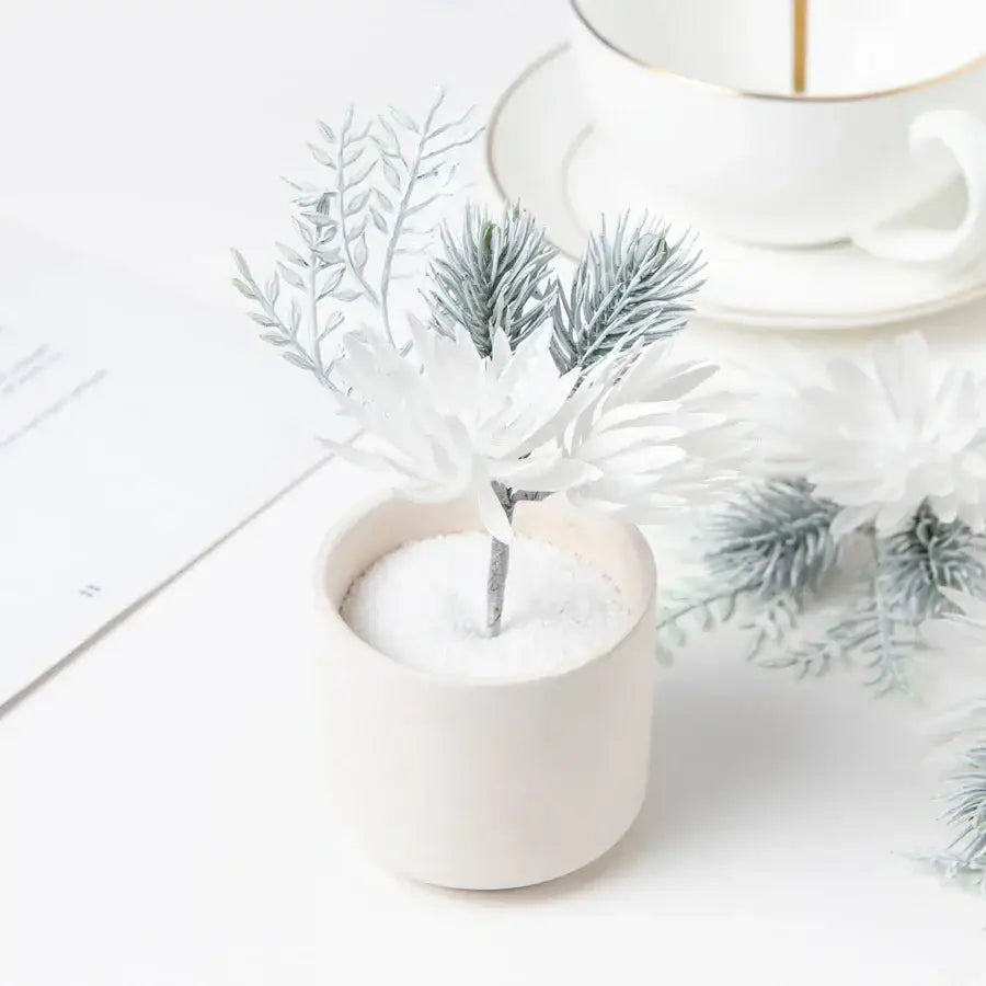 Delicate white and silver artificial flowers garland with silver-tipped branches in an off-white ceramic pot decorbites artificial flowers
