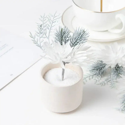 Delicate white and silver artificial flowers garland with silver-tipped branches in an off-white ceramic pot decorbites artificial flowers