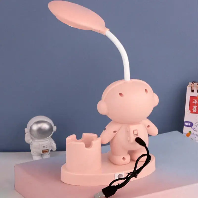 Pink astronaut-shaped desk lamp with flexible neck and leaf-like light head for decorbites astronaut study with pencil sharpener