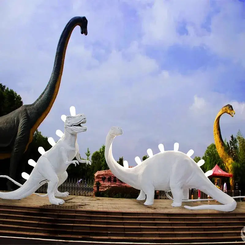 White resin led desk lamp featuring brontosaurus and t-rex dinosaur statues with glowing back spines for bedroom use