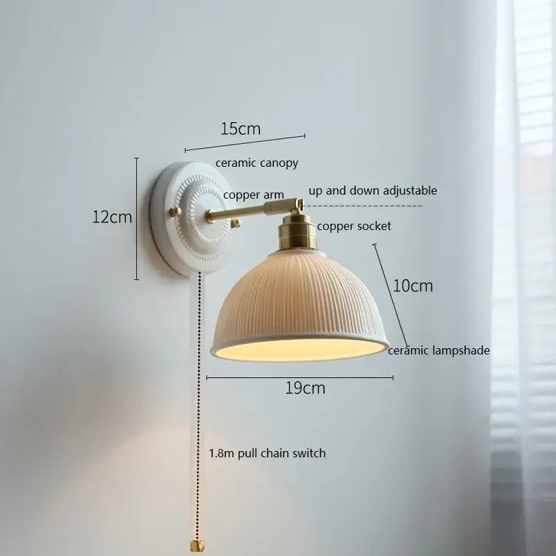 Cream-colored butterfly ceramic led wall lamp with vertical ridges mounted on brass copper arm for bedroom sconce