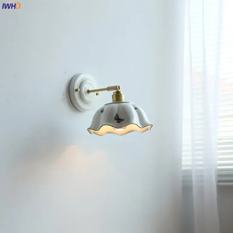 White butterfly ceramic led wall lamp with gold metal arm and scalloped black butterfly ceramic led sconce shade