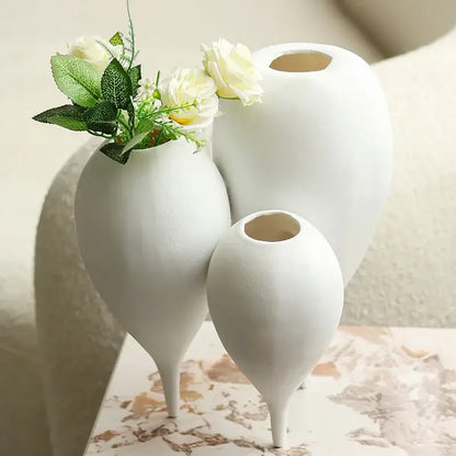Three white ceramic balloon geometric vases with slender teardrop shapes in a geometric vase trio for living room decor