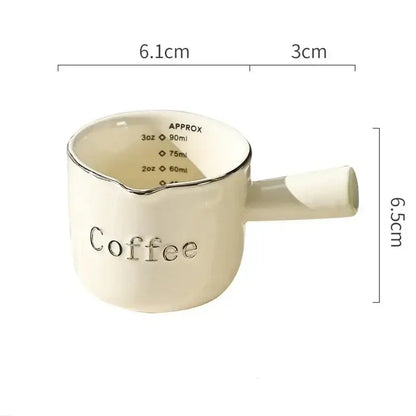 Cream-colored ceramic espresso measuring cup with silver rim and handle engraved coffee for decorbites latte mixer and milk pitcher