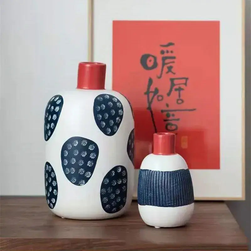 White ceramic polka dot vase with navy blue spots and a red neck featuring colorful graffiti lines for living room decor