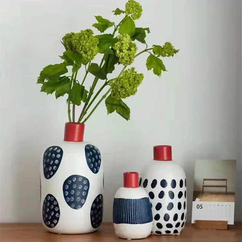 White ceramic polka dot vase with navy blue dots and red neck featuring colorful graffiti lines for living room decor