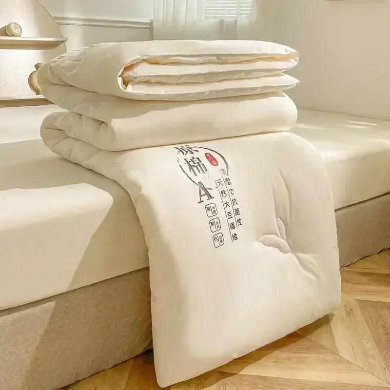 Cream-colored embroidered duvet with soft plush texture and subtle stitching featuring cotton soya fibre filling for comfort