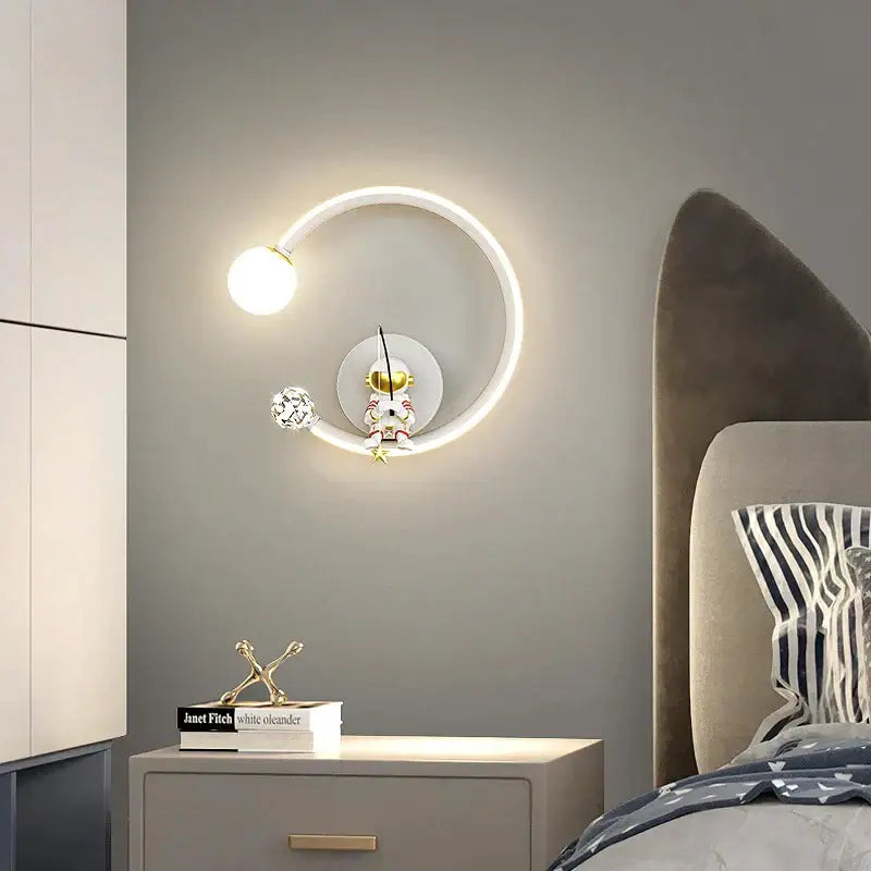 Modern circular white crescent astronaut wall lamp with glowing ring and gold-toned figurine for bedroom decorbites astronaut wall