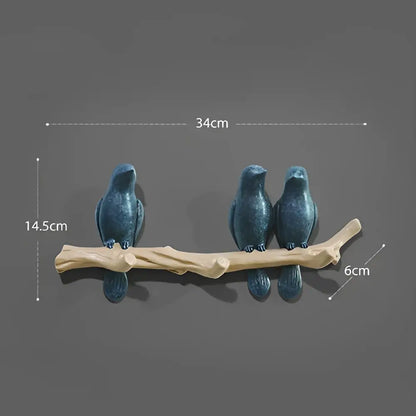 Three dark blue ceramic birds perched on a light brown wooden branch bird resin hanger decorbites bird resin