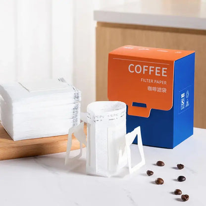 White disposable coffee filter bags with triangular stand design beside vibrant orange and blue decorbites coffee filter packaging